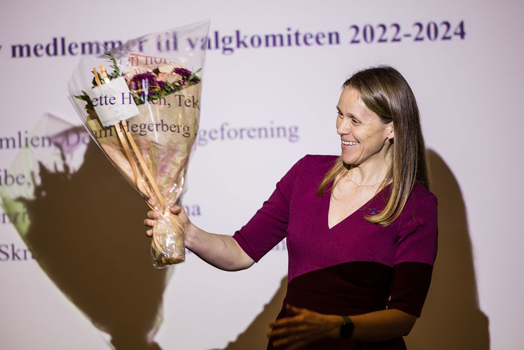 Leder i Akademikerne mottar en blomsterbukett og smiler mens hun holder blomstene i været