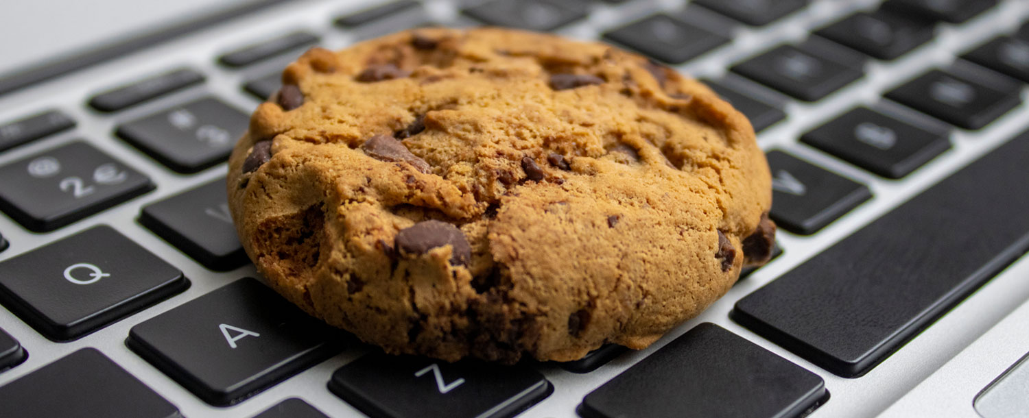 Et bilde av en chocolate-chips cookie oppå et tastatur